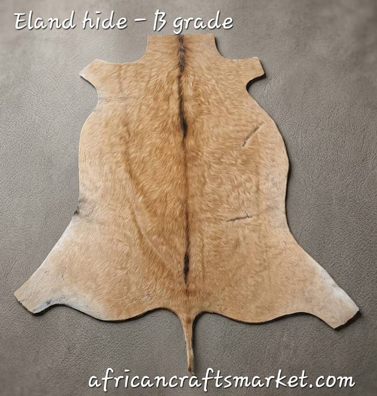 Large tanned African B-Grade Eland skin hide flat lay showing its rich tawny-fawn color, broad dimensions, and subtle natural character lines