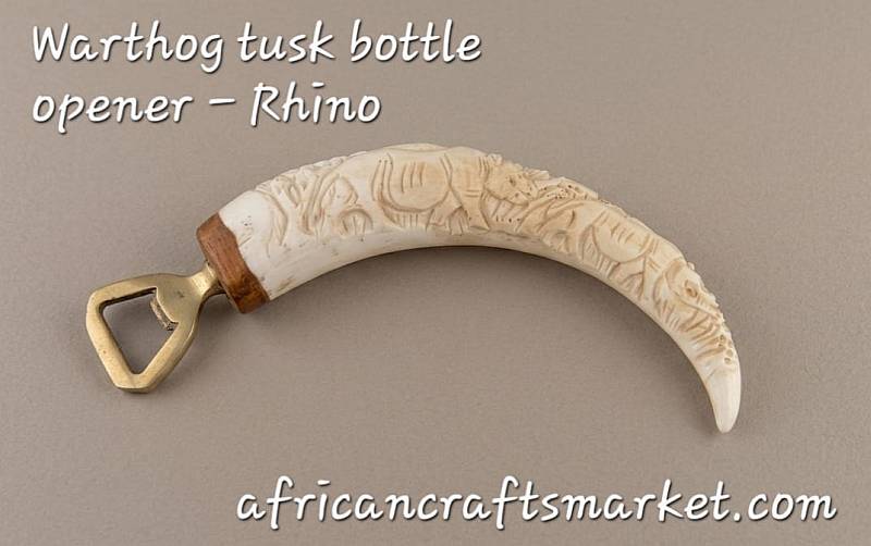 Warthog tusks bottle openers - Rhino Hand-carved African warthog tusk bottle opener featuring a detailed relief carving of a rhinoceros along the natural curve of the tusk