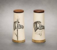 Table Decor | Luxury African Wood Tableware A set of bone inlay scrimshaw salt and pepper shakers displayed on a rustic dining table as part of a luxury African safari themed table setting